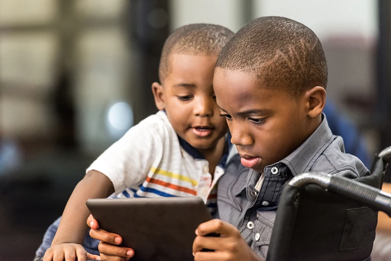 two young students looking at a tablet together